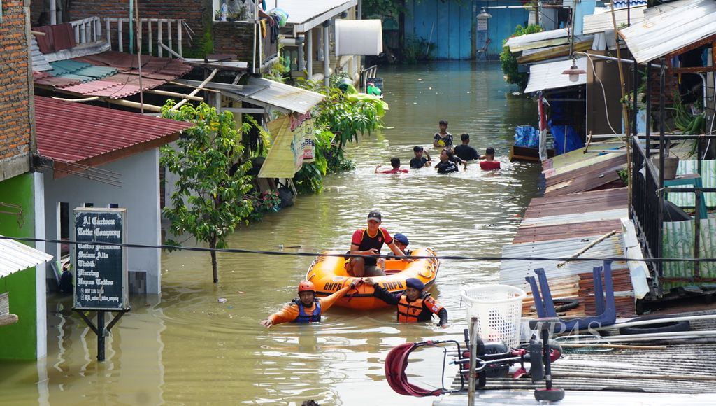 Proses evakuasi dari kampung terdampak banjir di Kelurahan Pucangsawit, Kecamatan Jebres, Kota Surakarta, Jawa Tengah, Jumat (17/2/2023). Perkampungan tersebut berada di tepi Sungai Bengawan Solo. Namun, banjir lebih disebabkan oleh derasnya aliran air dari sungai-sungai kecil di wilayah perkotaan.