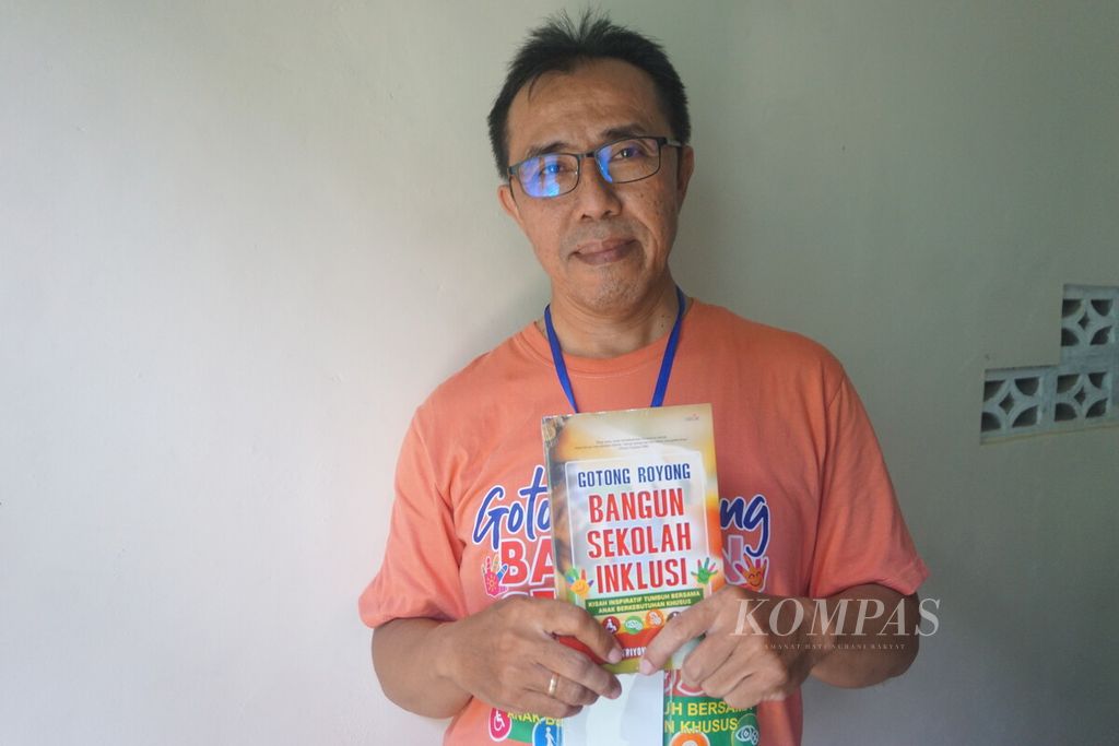Sutriyono Robert menunjukkan bukunya berjudul <i>Gotong Royong Bangun Sekolah Inklusi</i> di Cilacap, Jawa Tengah, Selasa (27/2/2024).