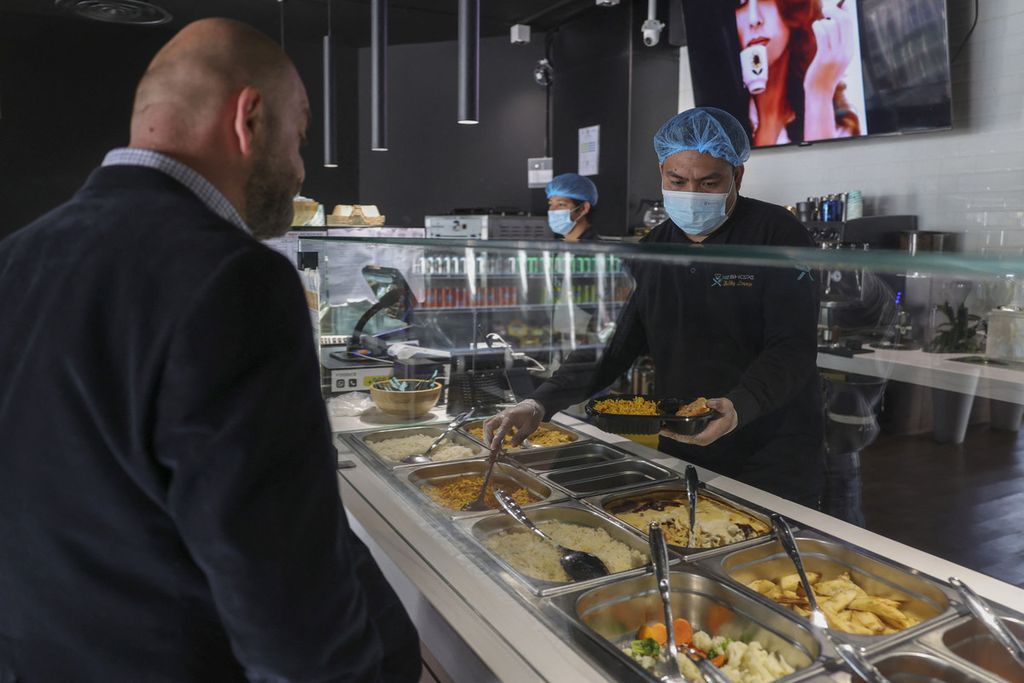 Seorang karyawan restoran (kanan) menyiapkan makanan diet untuk pelanggan di Riyadh, Arab Saudi, 12 Februari 2023. 