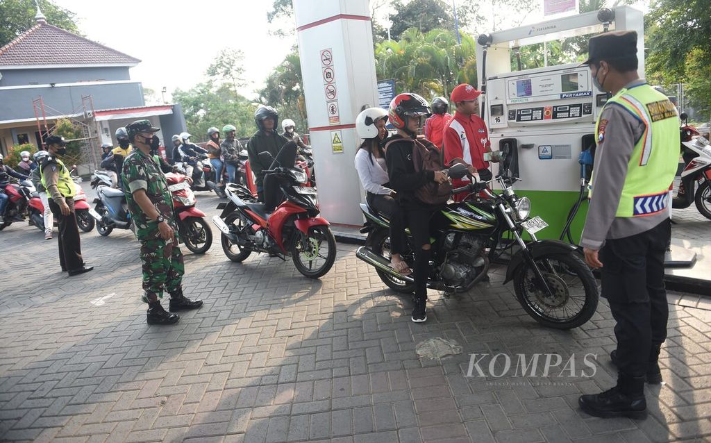 Petugas kepolisian Polsek Singosari bersama anggota Koramil 0818/26 Singosari berjaga setelah kenaikan harga BBM di salah satu SPBU di Kabupaten Malang, Jawa Timur, Sabtu (3/9/2022). 