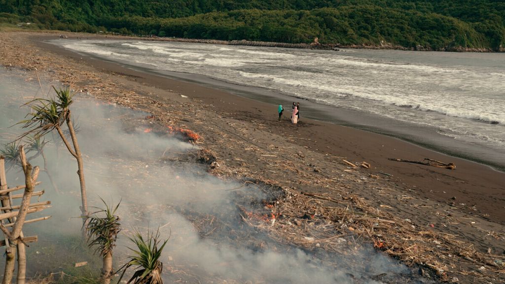 Sampah yang memenuhi bibir Pantai Pancer Puger dibakar di Puger Kulon, Kabupaten Jember, Jawa Timur, Sabtu (11/12/2021). Sampah yang sudah seminggu mengotori kawasan pantai itu berasal dari aliran empat sungai yang bermuara di pantai tersebut.