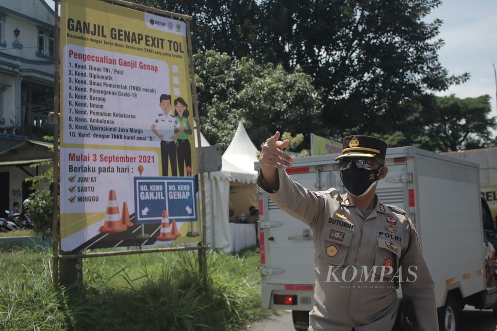 Salah satu petugas mengatur kendaraan yang keluar dari Gerbang Tol Buah Batu, Kota Bandung, Jumat (3/9/2021). Akhir pekan ini, akses masuk Kota Bandung melalui tol memberlakukan ganjil genap untuk meminimalkan kendaraan yang masuk dari luar Kota Bandung.