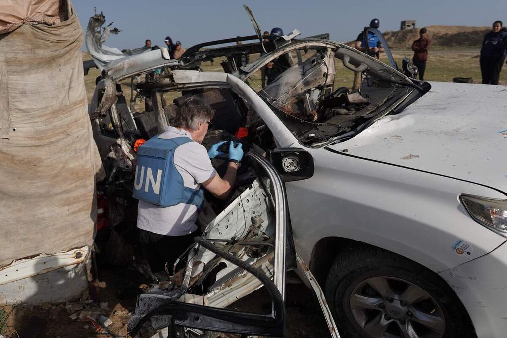 Staf Perserikatan Bangsa-Bangsa meneliti mobil yang digunakan sukarelawan World Central Kitchen pada 2 April 2024. Serangan Israel satu hari sebelumnya mengakibatkan tujuh sukarelawan terbunuh.