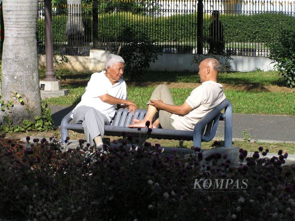 Dua warga lanjut usia berbincang-bincang sambil berjemur di salah satu taman di Kota Bandung, Jawa Barat, 22 Juli 2007.