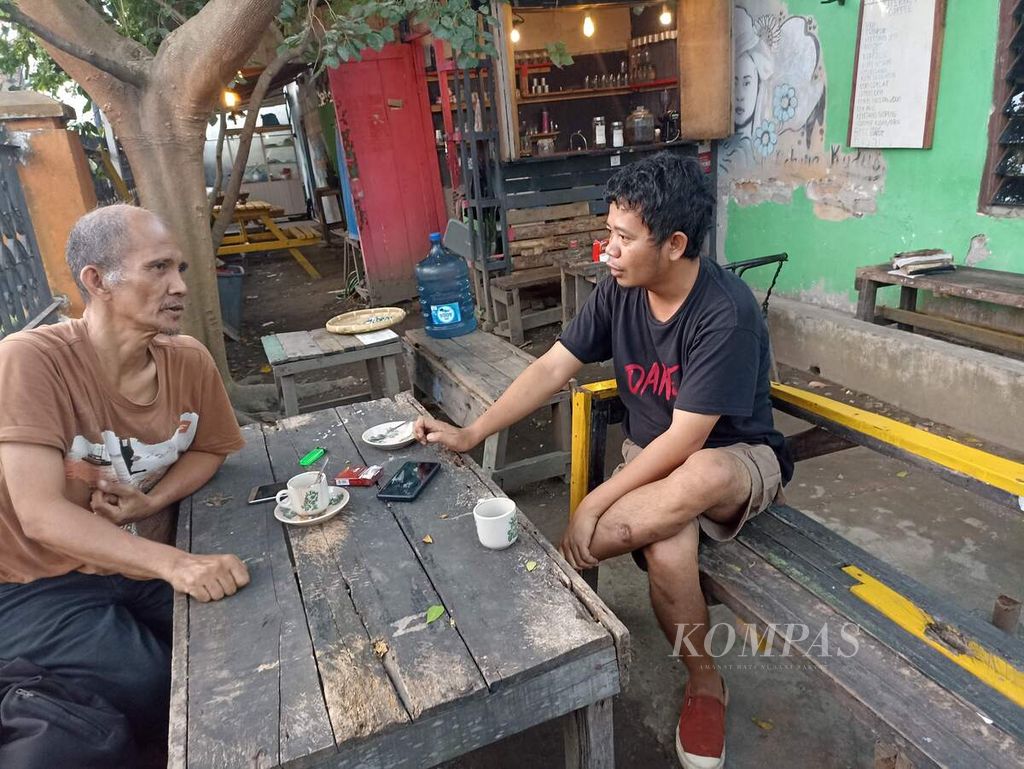 Pemilik Literacy Coffee, Jhon Fawer Siahaan, berdiskusi bersama pengunjung di Jalan Jati II, Medan, Sumatera Utara, Senin (18/7/2022). Kafe itu memadukan kopi, buku, dan media sosial.