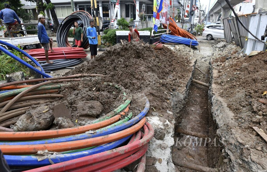 Sejumlah pekerja beristirahat setelah memindahkan gulungan kabel fiber optik di Kebayoran Baru, Jakarta Selatan, Kamis (19/8/2021). 