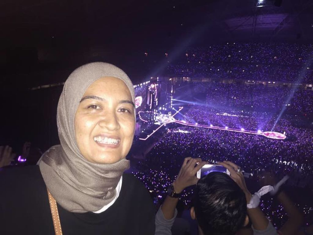 Wartawan <i>Kompas</i>, Dwi As Setianingsih, saat meliput konser Coldplay di National Stadium, Singapura, Sabtu (1/4/2017).