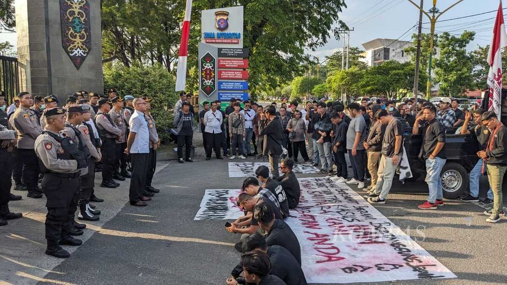 Polisi menjaga puluhan mahasiswa yang beraksi di depan kantor Polda Kalteng, Senin (23/10/2023) siang, di Kota Palangkaraya, Kalimantan Tengah. 