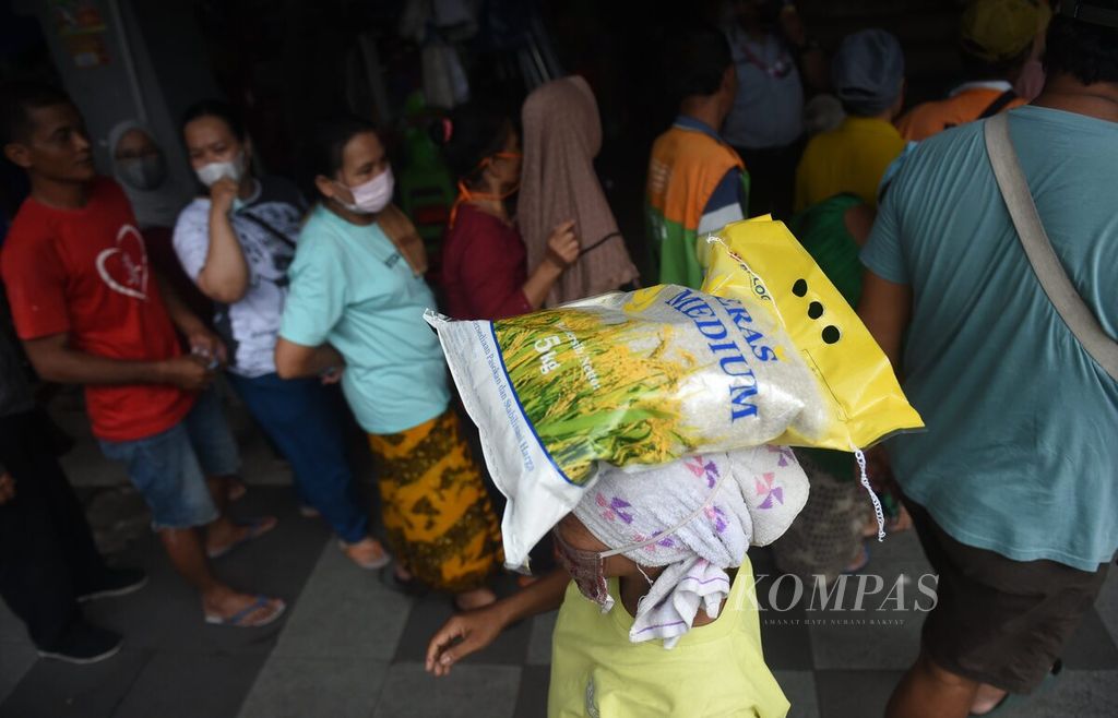 Pedagang membawa beras medium yang dibeli saat Operasi Pasar Beras di Pasar Genteng Baru, Surabaya, Jawa Timur, Kamis (9/2/2023). 