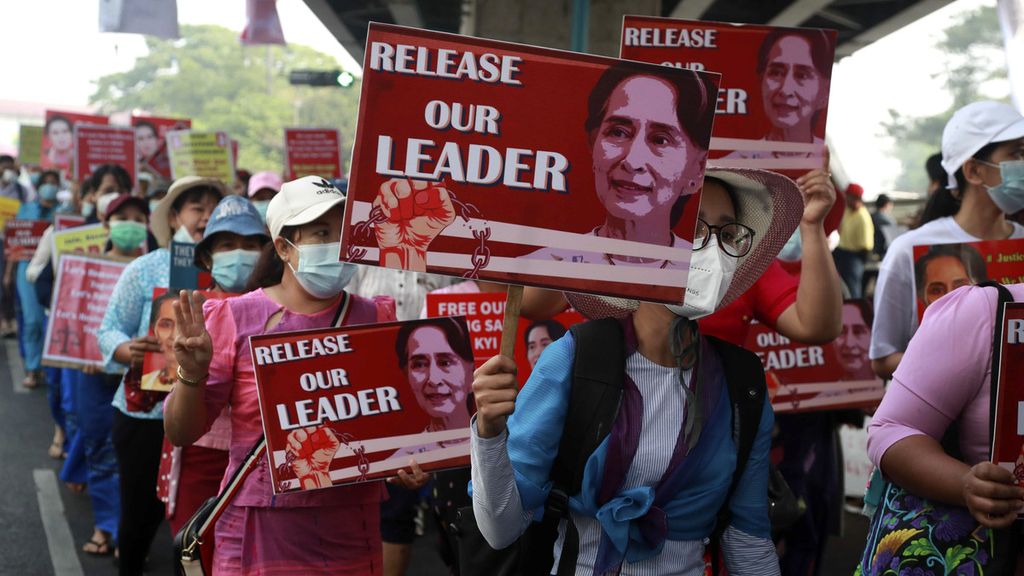 Sejumlah pengunjuk rasa membawa poster pemimpin Myanmar yang digulingkan, Aung San Suu Kyi, di Yangon, Myanmar, Jumat (26/2/2021). 