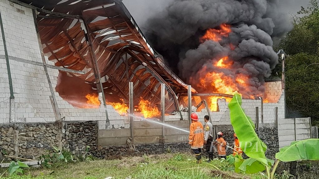 Petugas pemadam kebakaran memadamkan api yang membakar gudang pabrik kertas di Pandanlandung, Wagir, Kabupaten Malang, Jawa Timur, Jumat (16/9/2022)