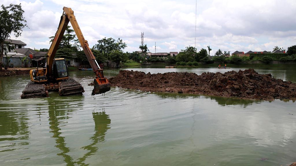 Petugas Unit Pengelola Kegiatan Badan Air Dinas Lingkungan Hidup DKI Jakarta membersihkan situ dari sampah di Situ Pesanggrahan, Petukangan Selatan, Jakarta Selatan, Senin (19/2). Situ itu antara lain untuk menampung air saat musim hujan sehingga bisa mencegah banjir.