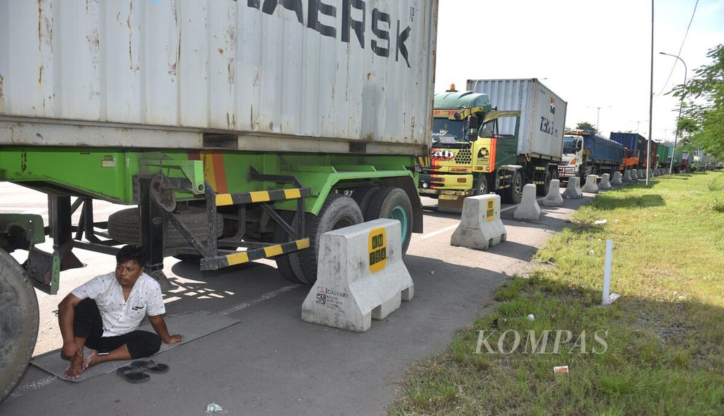 Sopir truk menunggu di bawah truknya saat antre untuk mendapatkan solar di SPBU <i>rest area</i> Km 754 Jalan Tol Surabaya-Gempol, Kabupaten Sidoarjo, Jawa Timur, Selasa (5/4/2022). 