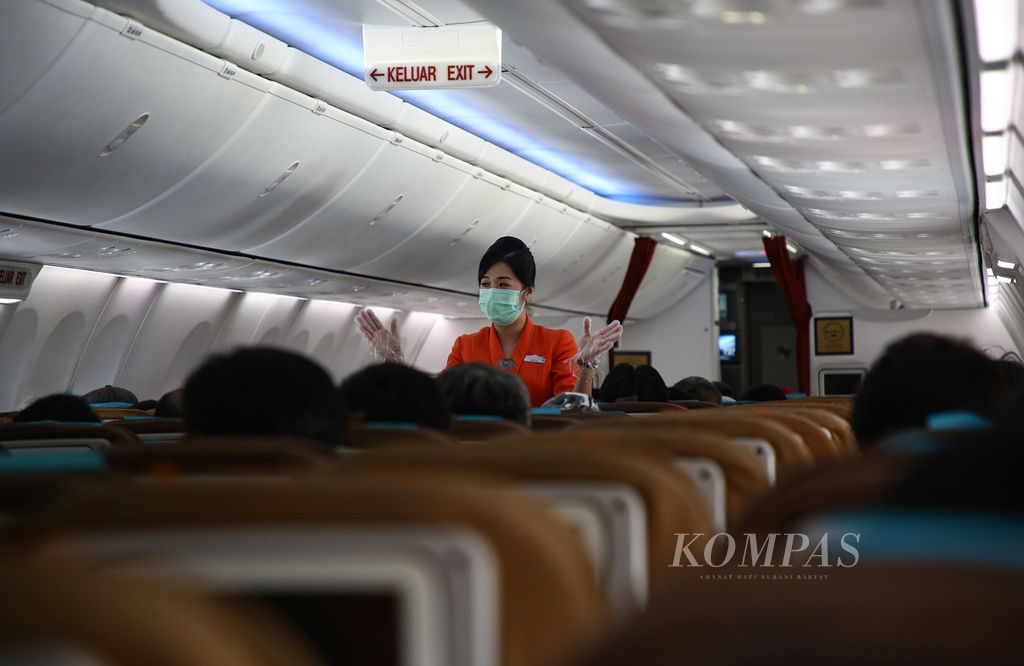 Pramugari menyampaikan standar keselamatan penerbangan kepada penumpang pesawat tujuan Balikpapan, Kalimantan Timur dari Bandara Internasional Soekarno-Hatta, Kota Tangerang, Banten, Minggu (7/3/2021). 