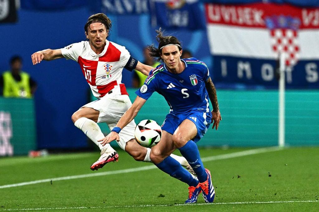 Gelandang Kroasia Luka Modric dan bek Italia Riccardo Calafiori berebut bola dalam pertandingan Grup B Piala Eropa 2024 antara Kroasia dan Italia di Stadion Red Bull Arena, Leipzig, Jerman, Selasa (25/6/2024) dini hari WIB.