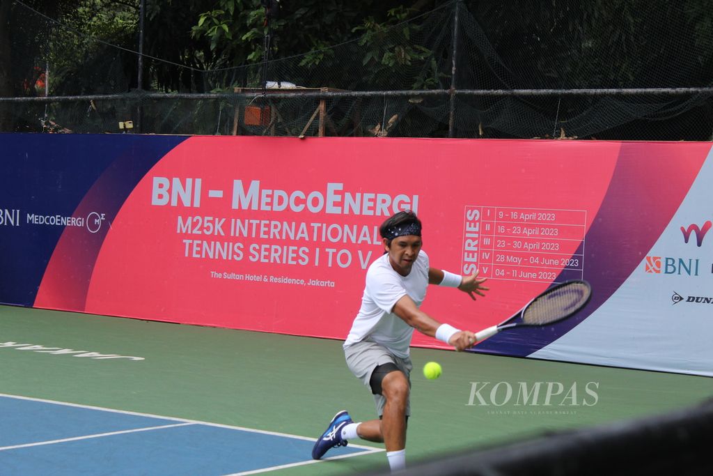 Salah petenis senior Indonesia Christipher Rungkat mengembalikan bola servis petenis asal Turki, Yanki Erel, pada turnamen MedcoEnergi International Tennis M25K di Jakarta, Kamis (27/4/2023). Rungkat kalah dalam pertandingan itu dan gagal melaju ke babak berikutnya.