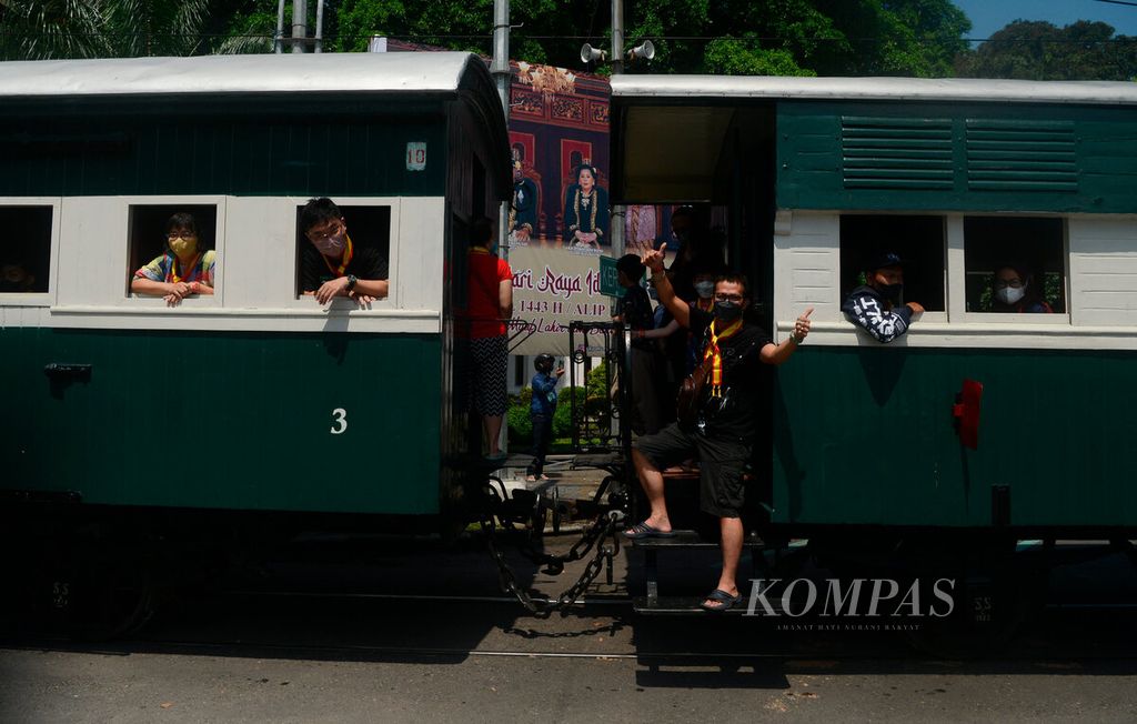 Wisatawan mengisi liburan dengan menaiki gerbong kereta uap saat melintas di Jalan Slamet Riyadi, Kota Surakarta, Jawa Tengah, Selasa (3/5/2022). Pada masa kini, kata <i>liburan</i> kerap disebut dengan <i>healing,</i> yang arti sesungguhnya adalah pemulihan.