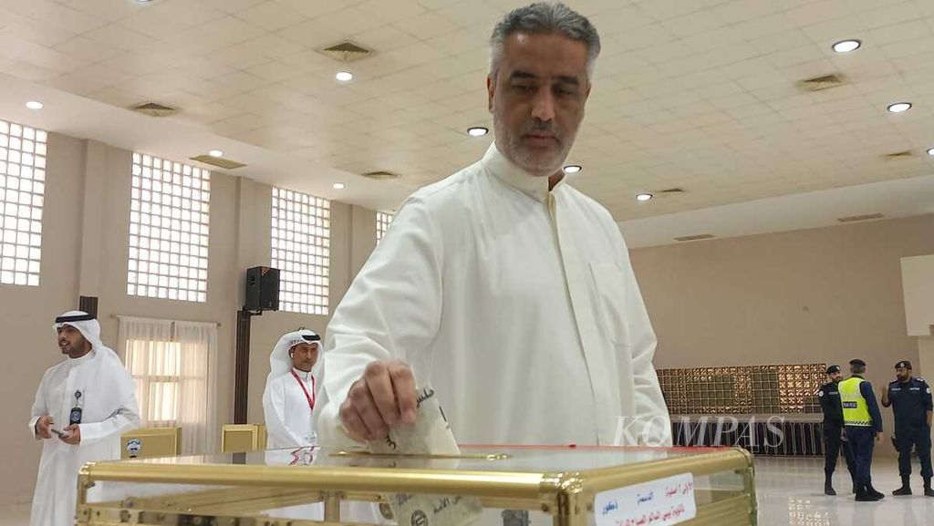 Seorang warga memasukkan kertas suara di sebuah kotak suara di TPS di sekolah menengah atas Bibi Al Salem Al Sabah di Dasma, Kuwait pada Selasa (6/6/2023).