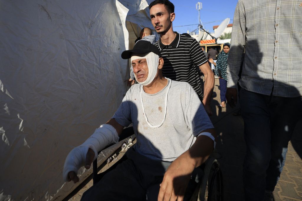 Warga Palestina yang terluka karena dalam serangan bom oleh Israel didorong di kursi roda di luar Rumah Sakit Al-Aqsa hospital, Deir al-Balah, pusat kota Jalur Gaza, 17 November 2023. 
