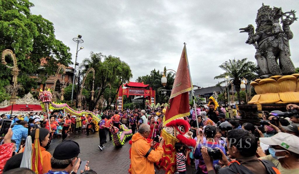 Warga di Kota Denpasar antusias menyaksikan pawai, yang memeriahkan pembukaan Festival Imlek Bersama 2023 di Kota Denpasar, Bali, Sabtu (28/1/2023). Pengunjung beramai-ramai menonton atraksi tari barongsai dan tari naga, yang ditampilkan secara massal di kawasan patung Catur Muka, Kota Denpasar, Sabtu (28/1/2023). 