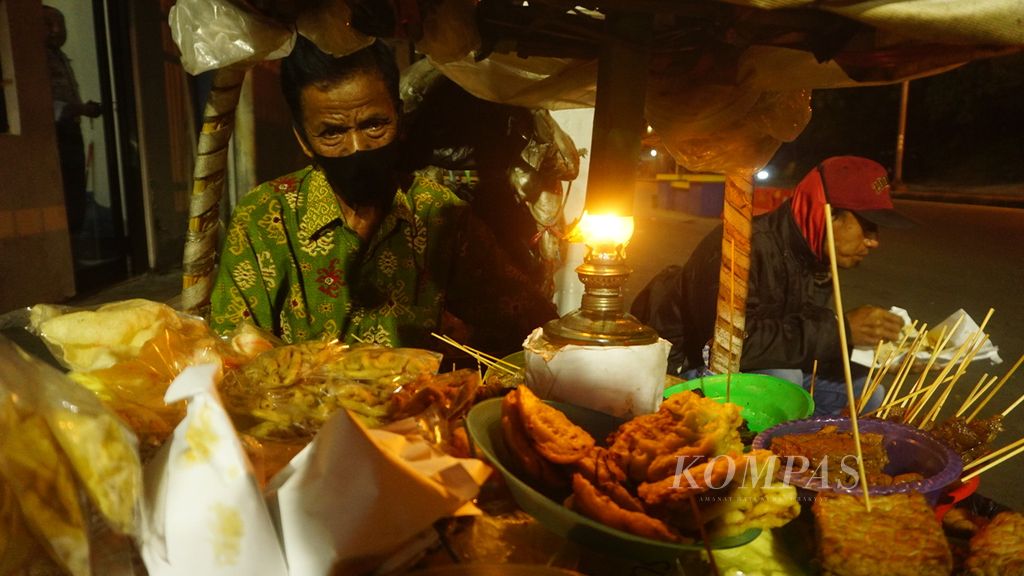 Penjual hik pikul menanti kedatangan pelanggan di Kota Surakarta, Jawa Tengah, Minggu (20/3/2022). Hik pikul menjadi bentuk paling awal dari kuliner murah meriah tersebut. Dalam perkembangannya, hik pikul kemudian berubah menjadi hik gerobak.