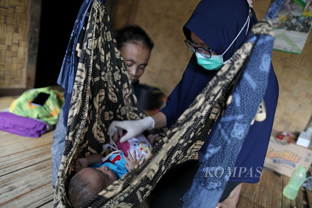 Bidan Pita Puspitasari memeriksa kesehaan anak balita di Posyandu Bungur V Kampung Gajeboh, Desa Kanekes, Kecamatan Leuwidamar, Kabupaten Lebak, Banten, Rabu (27/1/2021).