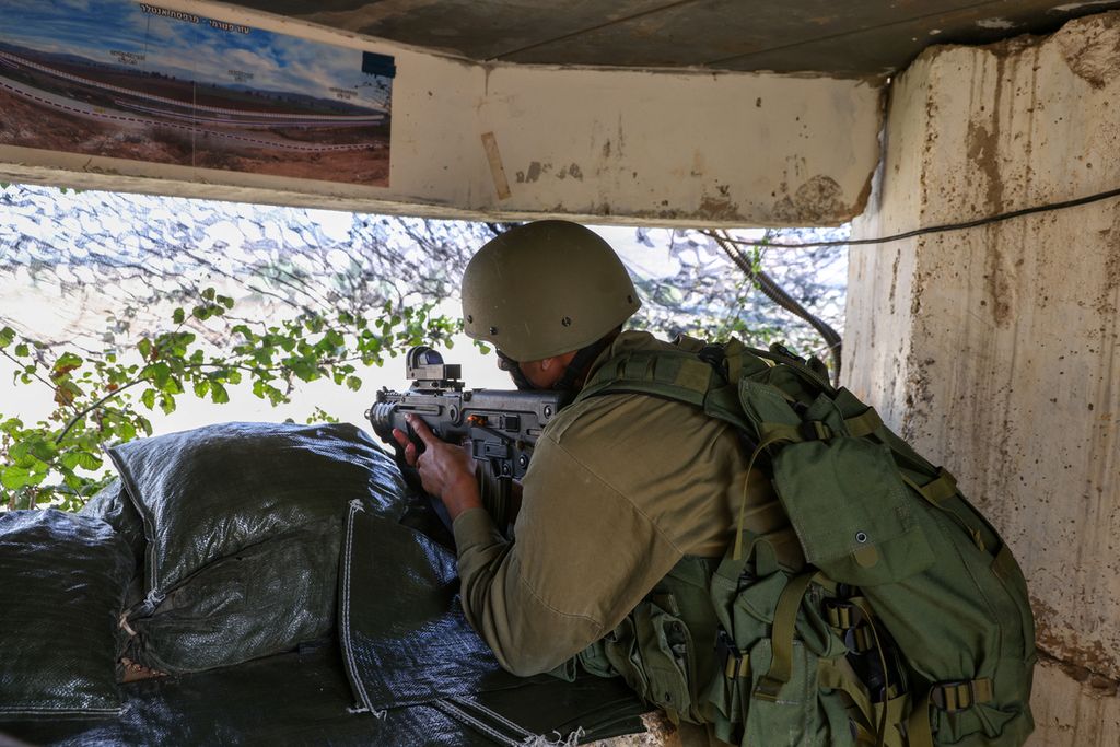 Seorang anggota pasukan Israel memantau dari kejauhan situasi di sekitar perbatasan dengan Lebanon di kota Metula, Israel utara, Minggu (8/10/2023). 