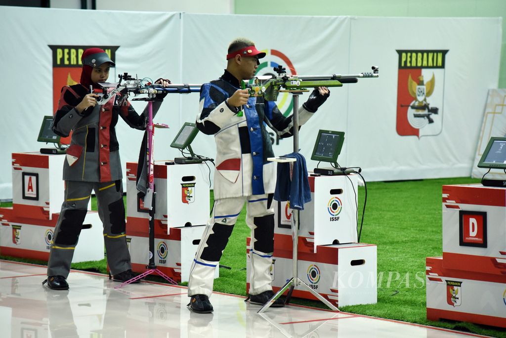 Pasangan Indonesia, Audrey Zahra Dhiyaanisa/Afif Izzuddin, memeriksa senjata sebelum dimulainya perebutan emas tim campuran senapan angin 10 meter Piala Asia Senapan dan Pistol 2023 di Lapangan Tembak Senayan, Jakarta, Minggu (5/3/2023). 