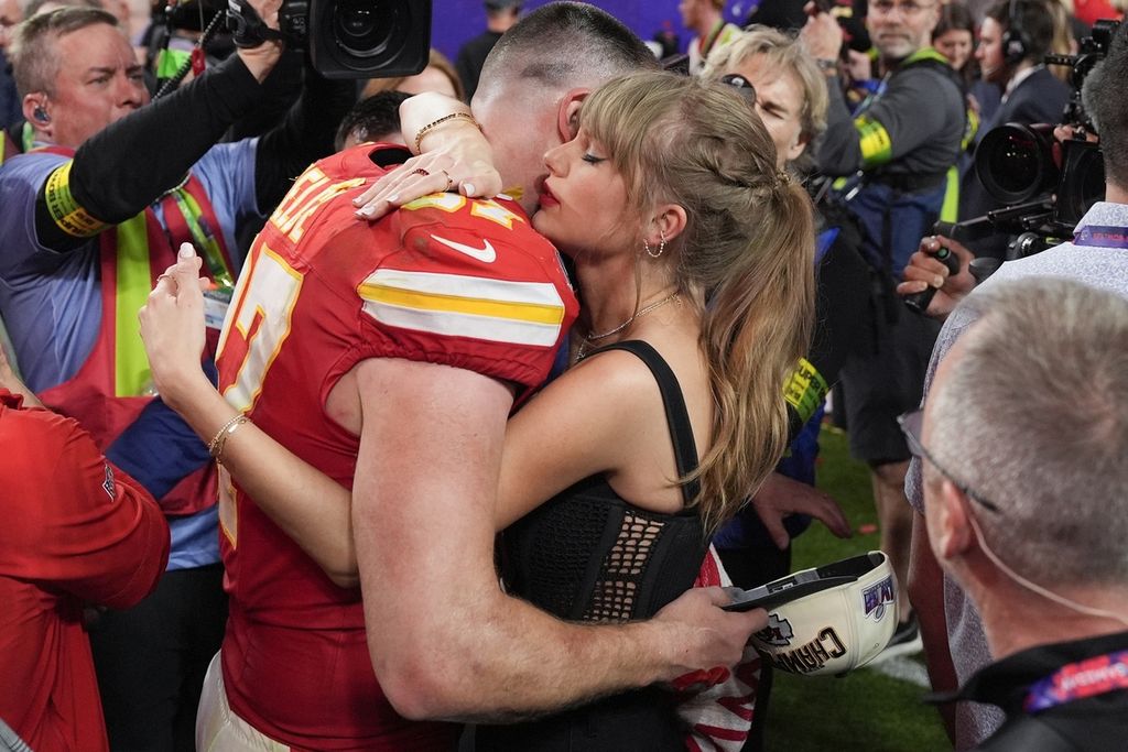 Penyanyi Taylor Swift memeluk pemain Kansas City Chiefs, Travis Kelce, setelah Kansas mengalahkan San Francisco 49ers pada laga pada laga NFL Super Bowl 58 di Las Vegas, Minggu (11/2/2024). Chiefs menjadi juara pada musim ini.