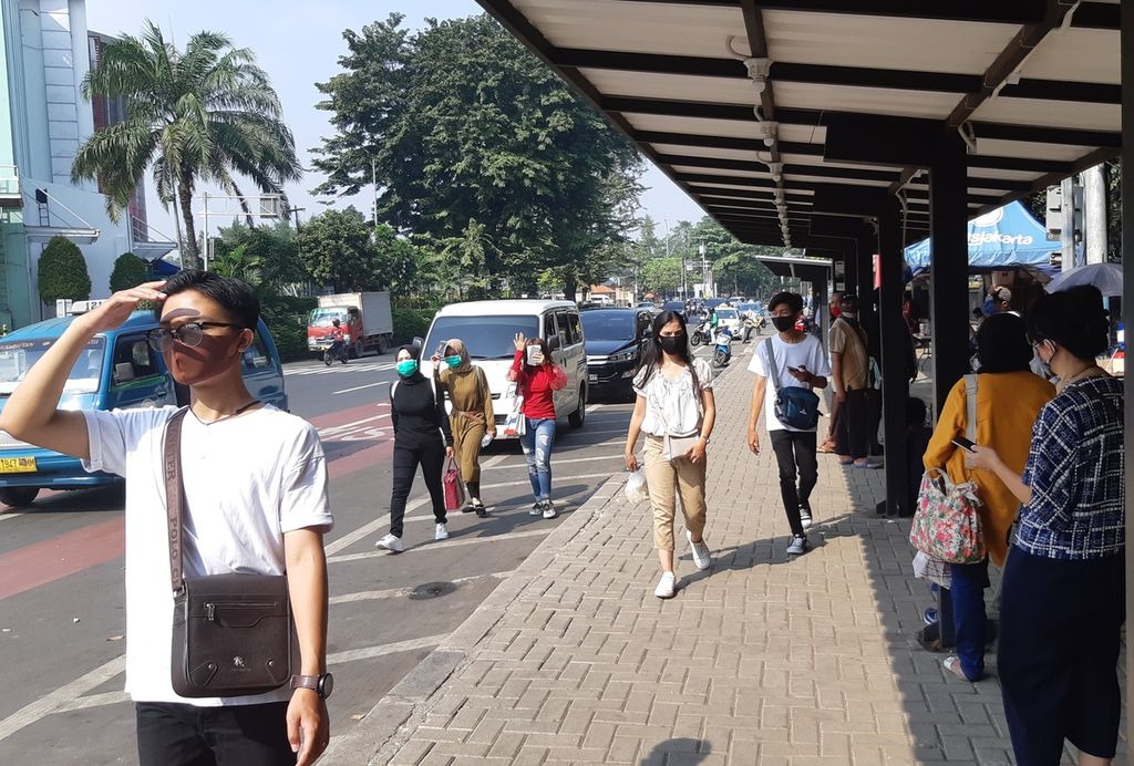  Warga menunggu bus di selter perhentian bus kawasan Cibubur, Jakarta Timur, Senin (20/7/2020). Selama pandemi Covid-19, sebagian warga yang melaju ke Jakarta urung naik moda transportasi umum.