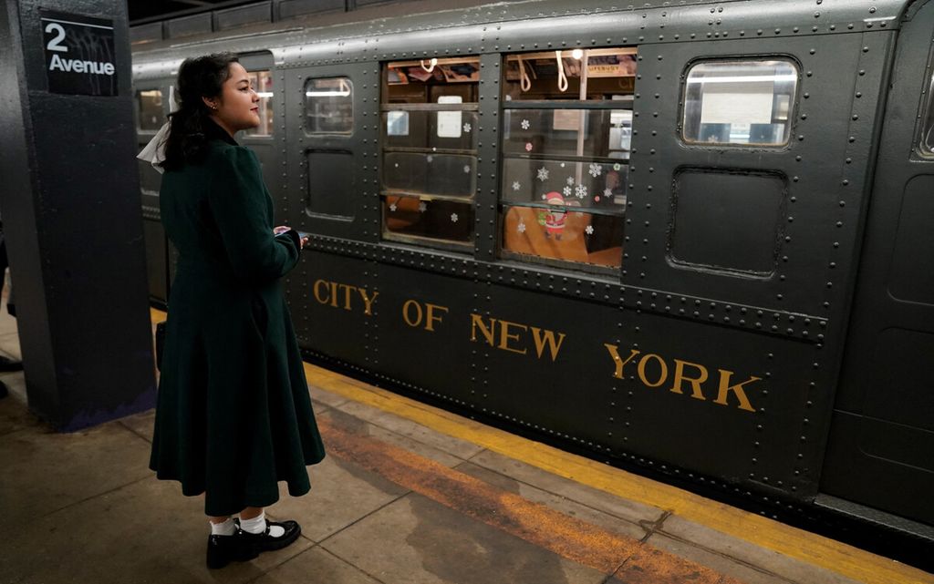 Seorang penumpang menunggu untuk menaiki Kereta Holiday Nostalgia di New York, Amerika Serikat, Minggu (8/12/2024). Kereta bawah tanah ”R1-9” kuno diperkenalkan pada 1930-an hingga dihentikan empat dekade kemudian yang terakhir ditarik dari relnya pada tahun 1977. 