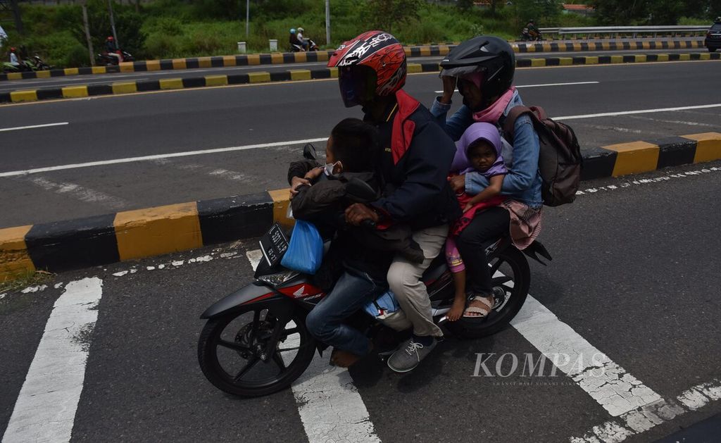 Dengan berdesakan bersama istri dan dua anaknya, pemudik bersepeda motor tiba di Pulau Madura setelah melewati Jembatan Suramadu di Kabupaten Bangkalan, Pulau Madura, Jawa Timur, Rabu (27/4/2022). 