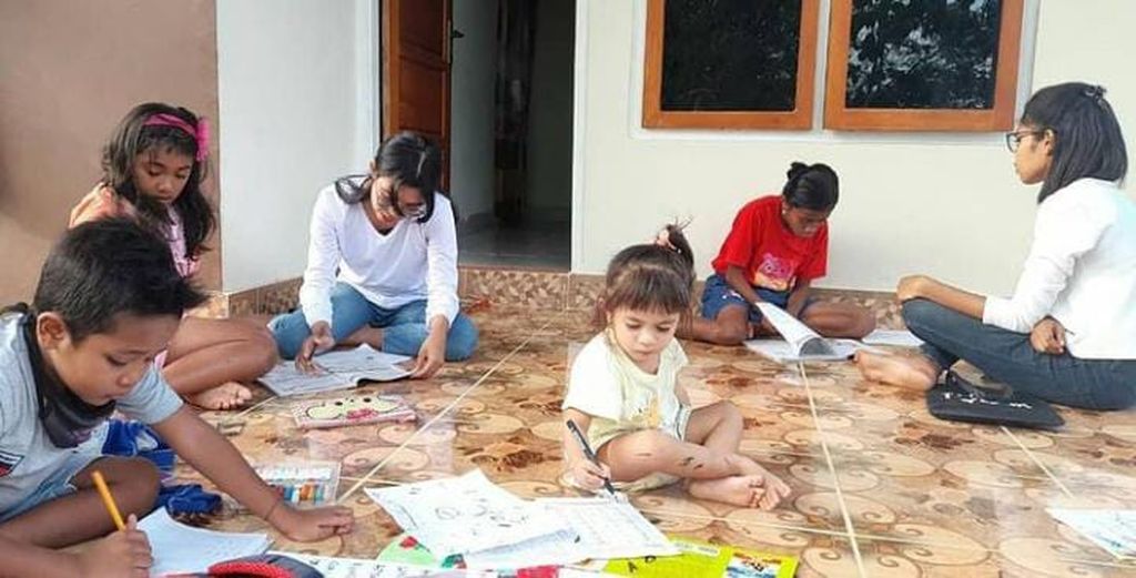 Beatrix Yunarti Manehat sedang mengarahkan anak-anak anggota taman baca untuk membaca, menulis, dan menghitung.