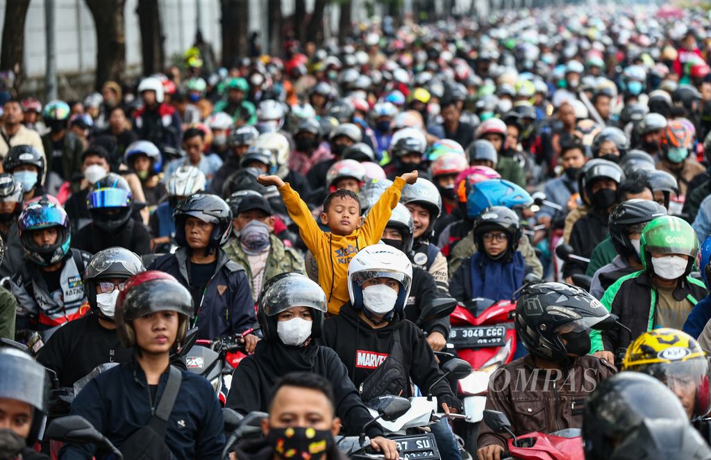 Seorang anak bereaksi saat mengantre bersama ribuan pemudik sepeda motor lainnya di pelabuhan Merak, Cilegon, Banten (30/4/2022) pagi.