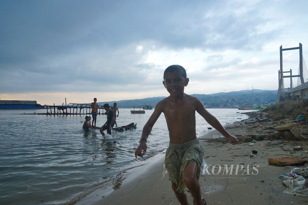 Di bawah langit hitam dan gemuruh, anak-anak tetap berenang dan bermain di tepi Teluk Kendari, Kecamatan Abeli, Kendari, Sulawesi Tenggara, Kamis (16/12/2023). Cuaca buruk mengintai di tengah transisi musim hujan saat ini.