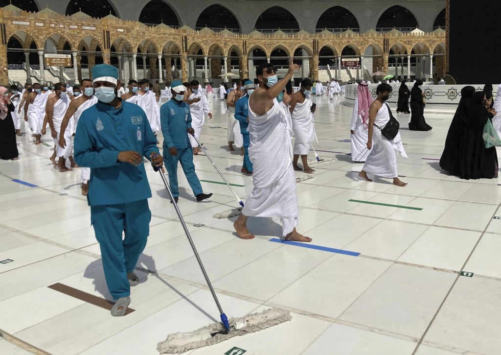 Pekerja melakukan sterilisasi di area Kabah di Masjidil Haram, Kota Suci Mekkah, Arab Saudi, dalam ibadah Umrah Minggu (30/5/2021).