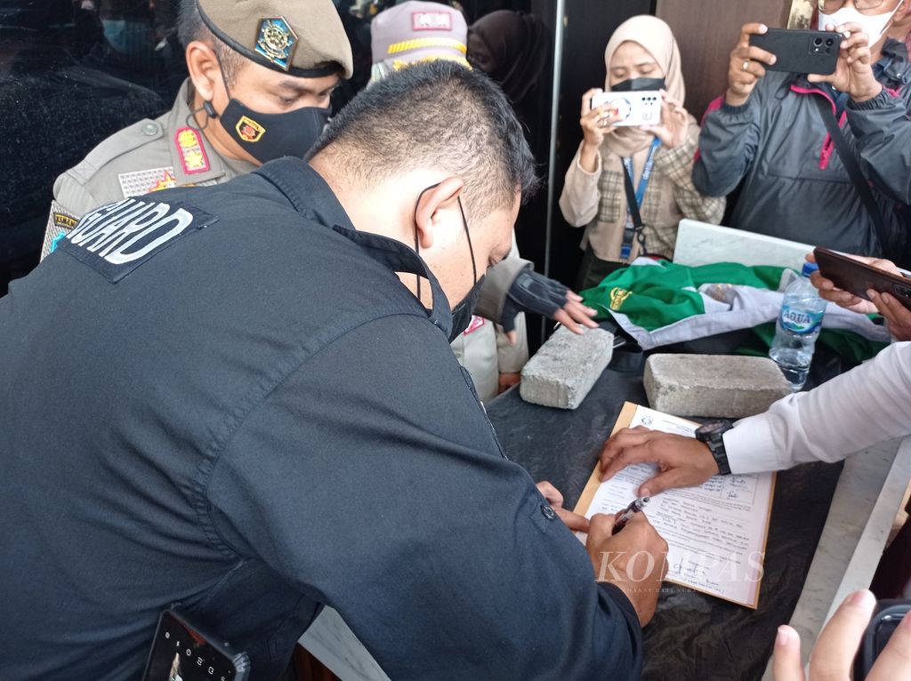 Petugas keamanan Holywings Reserve Senayan, Jalan Gerbang Pemuda 3, Jakarta Pusat, menandatangani berita acara penutupan izin usaha oleh Satuan Polisi Pamong Praja DKI Jakarta, Selasa (28/6/2022).