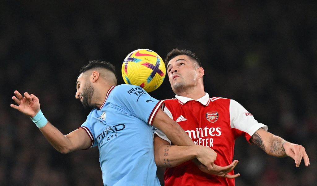 Penyerang Manchester City, Riyad Mahrez (kiri), berebut bola dengan gelandang Arsenal, Granit Xhaka, pada laga Liga Inggris di Stadion Emirates, London, Inggris, Kamis (16/2/2023) dini hari WIB. City menang, 3-1. 