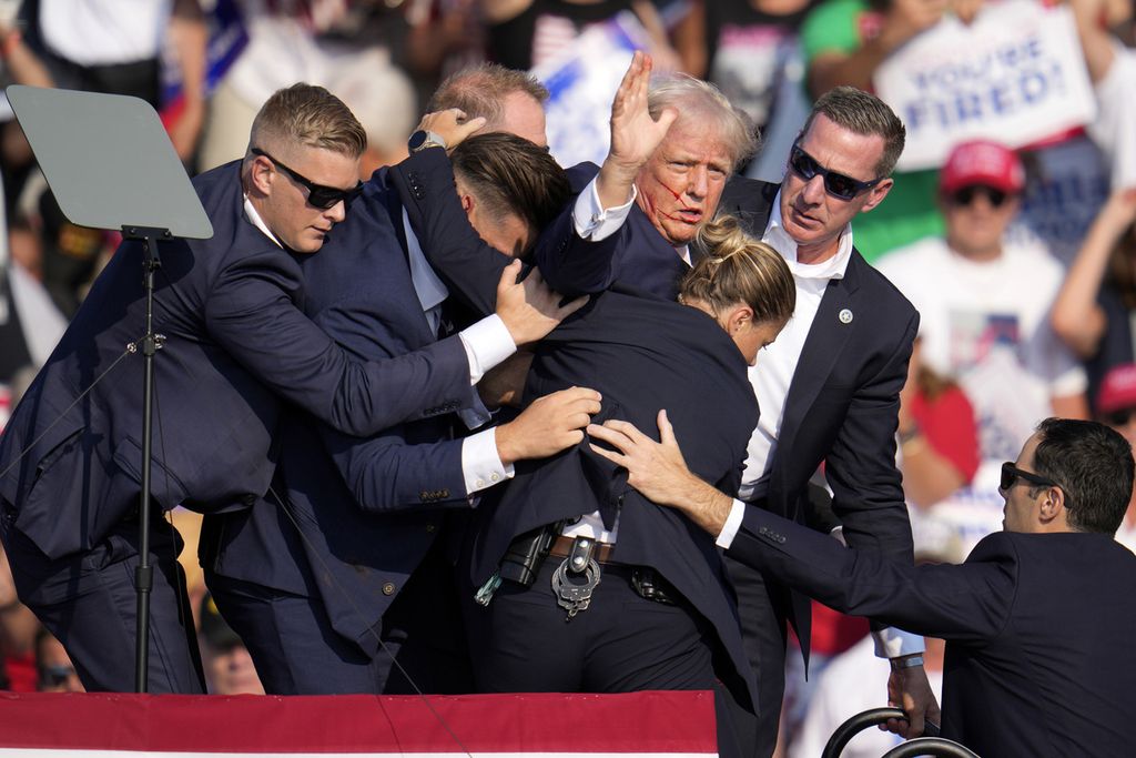 Kandidat presiden dari Partai Republik, mantan Presiden Donald Trump, dibantu turun dari panggung oleh Secret Service pada acara kampanye di Butler, Amerika Serikat, Sabtu (13/7/2024). 