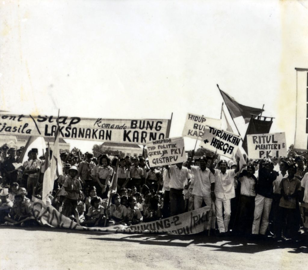 Suasana aksi mahasiswa dan pelajar saat unjuk rasa Tritura pada tahun 1966 di Jakarta. Para peserta aksi menggunakan spanduk dengan kata-kata yang lugas untuk menyampaikan tuntutan mereka.