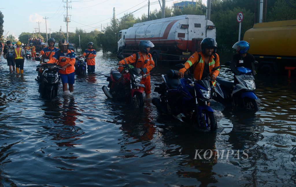Warga mengeluarkan kendaraan mereka yang tidak sempat diselamatkan saat pasang air laut membanjiri kawasan Pelabuhan Tanjung Emas di Kota Semarang, Jawa Tengah, Selasa (24/5/2022). 