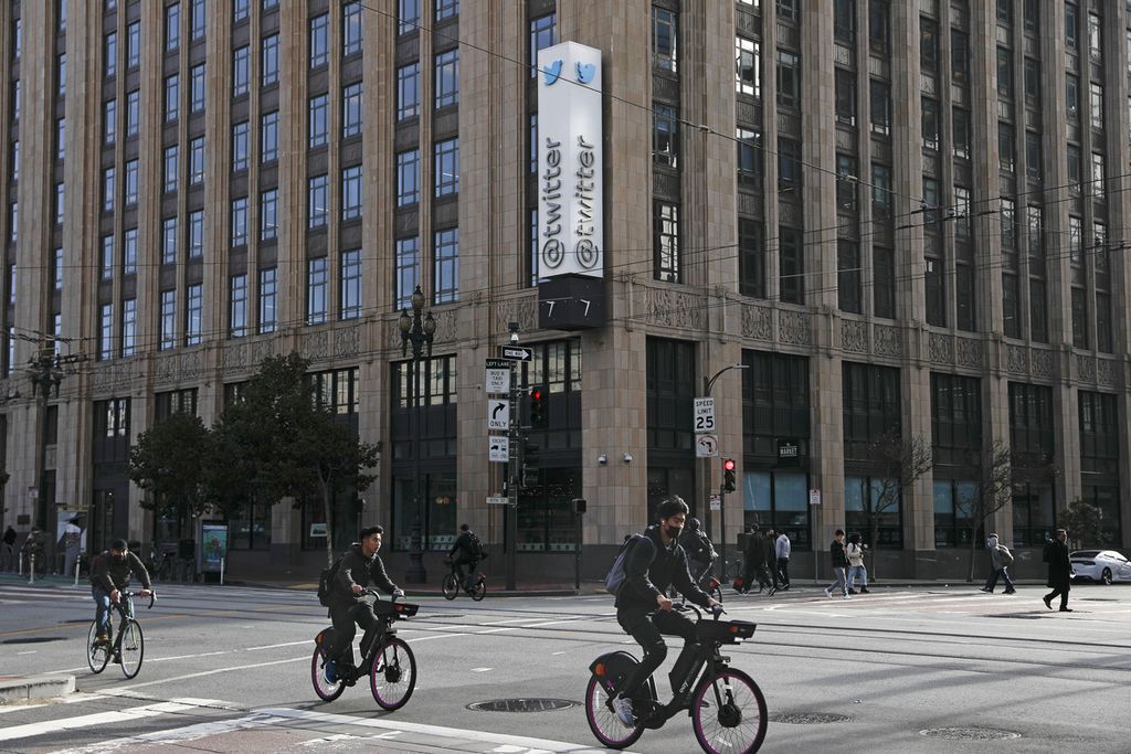 Sejumlah orang bersepeda di Market Street melewati Kantor Pusat Twitter di San Francisco, Jumat (4/11/2022). Twitter memutuskan hubungan kerja separuh pegawainya sebagai salah satu kebijakan Elon Musk, pemilik baru perusahaan media sosial itu. (Lea Suzuki/San Francisco Chronicle via AP)