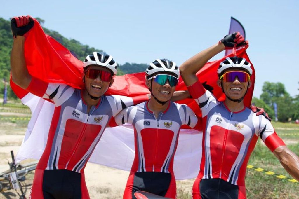 Para pebalap sepeda disiplin mountain bike, yaitu Feri Yudoyono (tengah) diapit Zaenal Fanani (kanan) dan Ihza Muhammad, merayakan kemenangan usai perlombaan nomor XCO Putra SEA Games 2023 di Kulen Mountains, Siem Reap, Kamboja, Sabtu. (6/5/2023)
