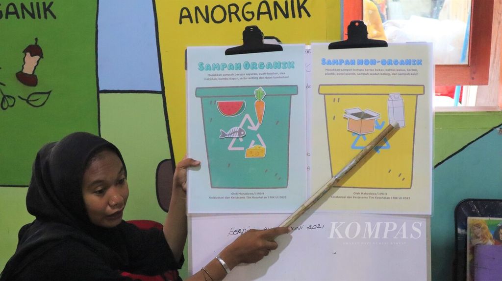 Dwi Oktaviani, seorang guru PAUD Bank Sampah Kenanga RW 004, Kelurahan Semper Barat, Cilincing, Jakarta Utara, tengah menjelaskan jenis sampah kepada murid-muridnya, Rabu (23/8/2023).