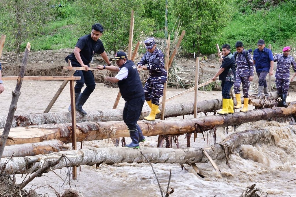 Penjabat Gubernur Sulawesi Selatan Bahtiar Baharuddin berjalan meniti jembatan kayu di Kecamatan Latimojong, Luwu, Kamis (9/5/2024). Hingga kini, sebagian desa di Luwu masih terisolasi.