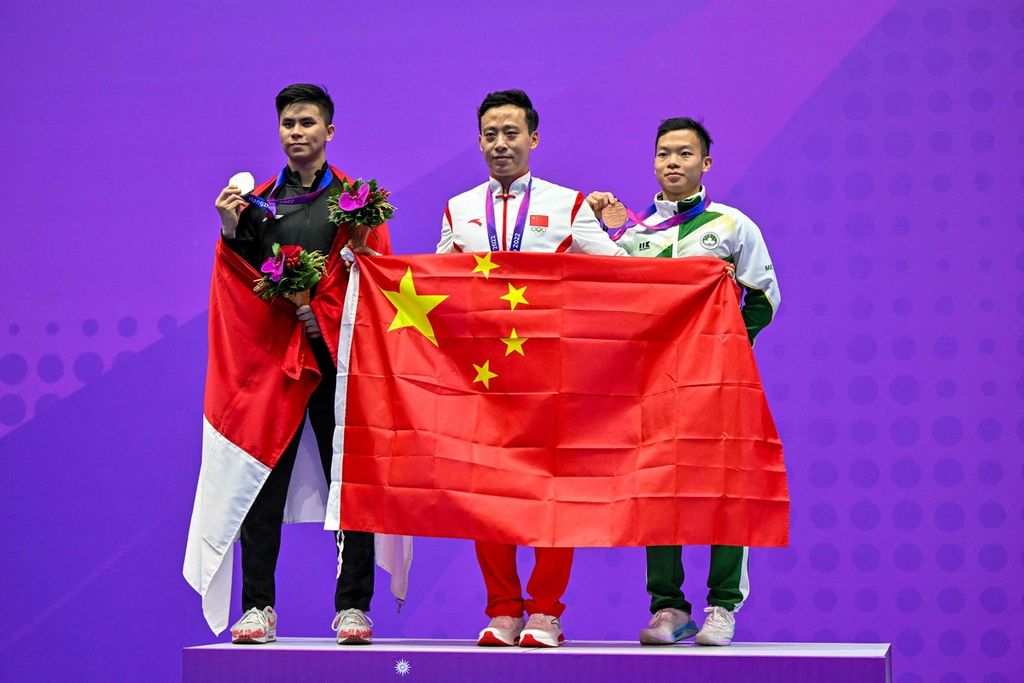 Peraih medali emas dari China, Sun Peiyuan (tengah); peraih medali perak dari Indonesia, Edgar Xavier Marvelo (kiri); dan peraih medali perunggu dari Makau, Song Chi-kuan; berpose di podium usai lomba wushu pada nomor changquan putra pada Asian Games Hangzhou 2022, Minggu (24/9/2023), di Hangzhou.