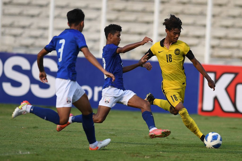 Pesepak bola Malaysia U-19, Adam Farhan Mohd Faizal (kanan), mencoba melewati hadangan pesepak bola Kamboja U-19, Chhan Bun My (kiri) dan Uk Devin (tengah), dalam laga penyisihan grup Piala AFF U-19 di Stadion Madya Senayan, Jakarta, Selasa (5/7/2022). Malaysia akan bertemu dengan Vietnam pada laga semifinal Piala AFF U-19 di Stadion Patriot Candrabhaga, Bekasi, Rabu (13/7/2022).
