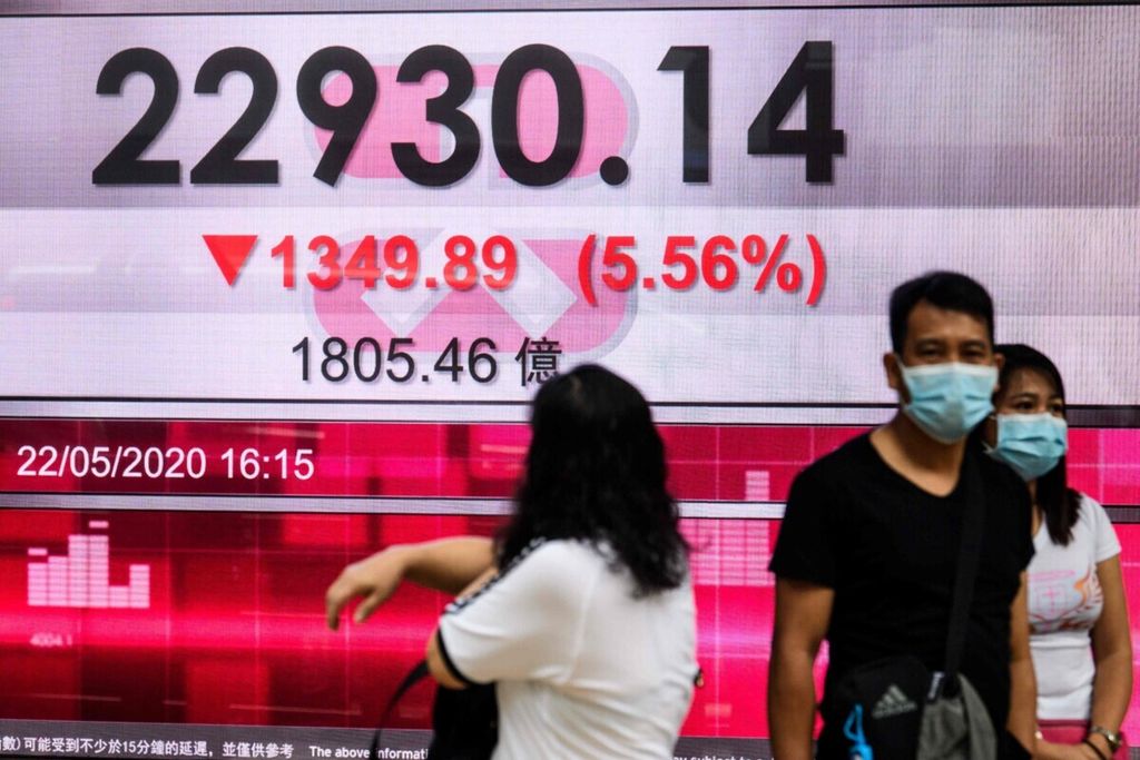 Seorang wanita melihat papan <i>display</i> saham yang menunjukkan Indeks Hang Seng (HSI) turun sebesar 5,56 persen setelah perdagangan ditutup untuk hari itu di Hong Kong pada 22 Mei 2020. 