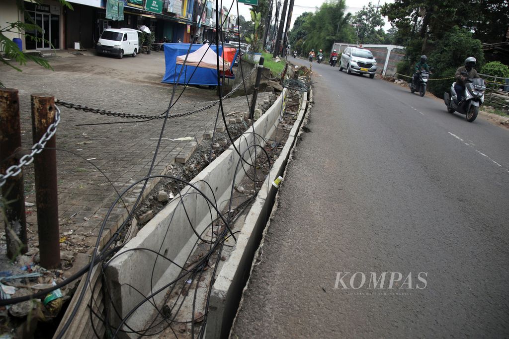Kabel dibiarkan semrawut di atas gorong-gorong di Jalan Merpati Raya, Tangerang Selatan, Kamis (29/9/2022). Ini bagian dari proyek relokasi jaringan utilitas dari atas ke bawah. Revitalisasi gorong-gorong sekaligus untuk mengendalikan banjir. 
