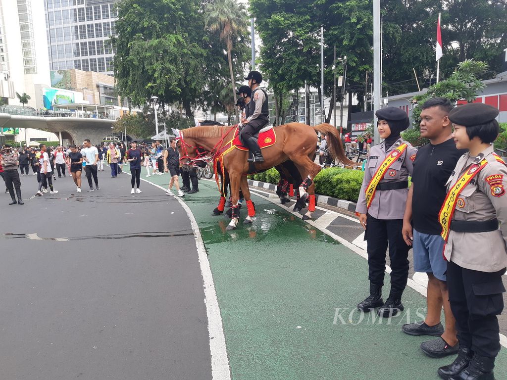Beberapa kuda tengah berpatroli di area hari bebas kendaraan bermotor di kawasan Bundaran Hotel Indonesia, Minggu (18/2/2024). Di momen tersebut, banyak warga yang berolahraga dan sesekali berfoto dengan kuda.
